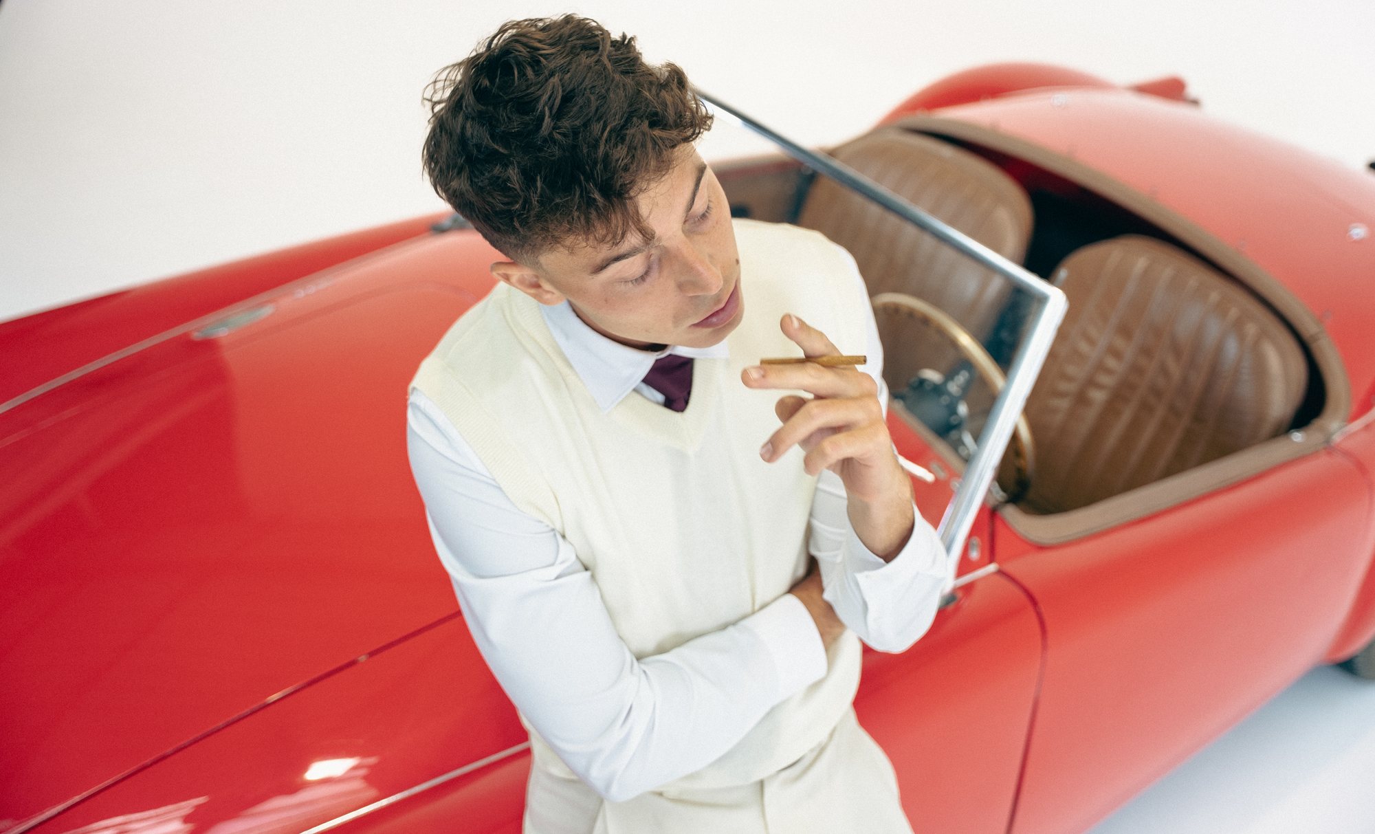 Rivers Garnham — cabriolet rouge, cigare