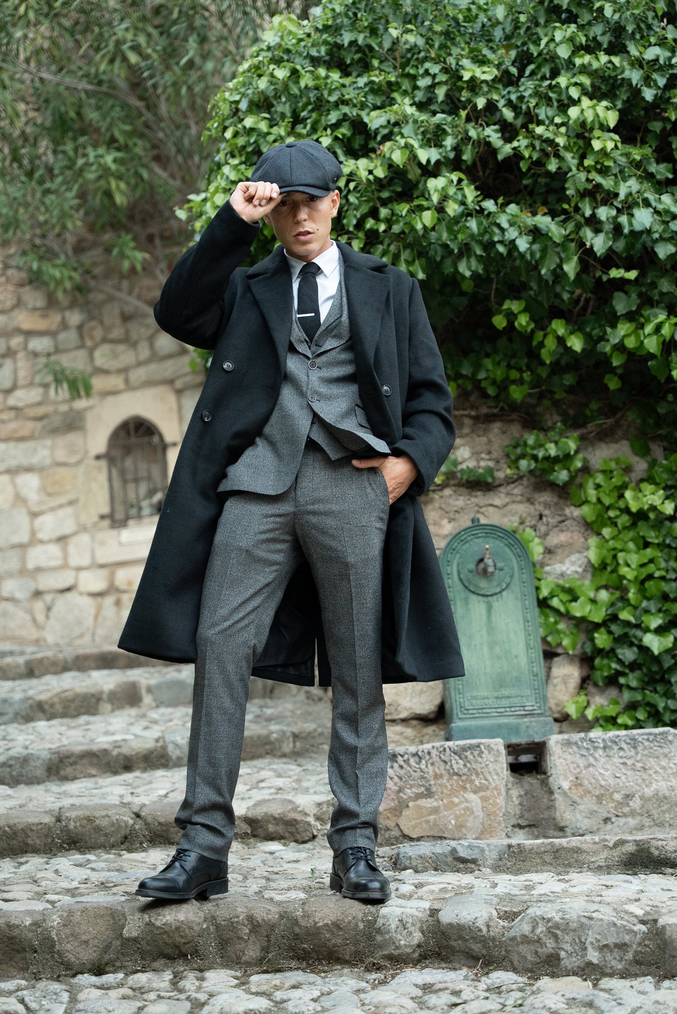 Rivers Garnham — manteau et casquette dans les escaliers